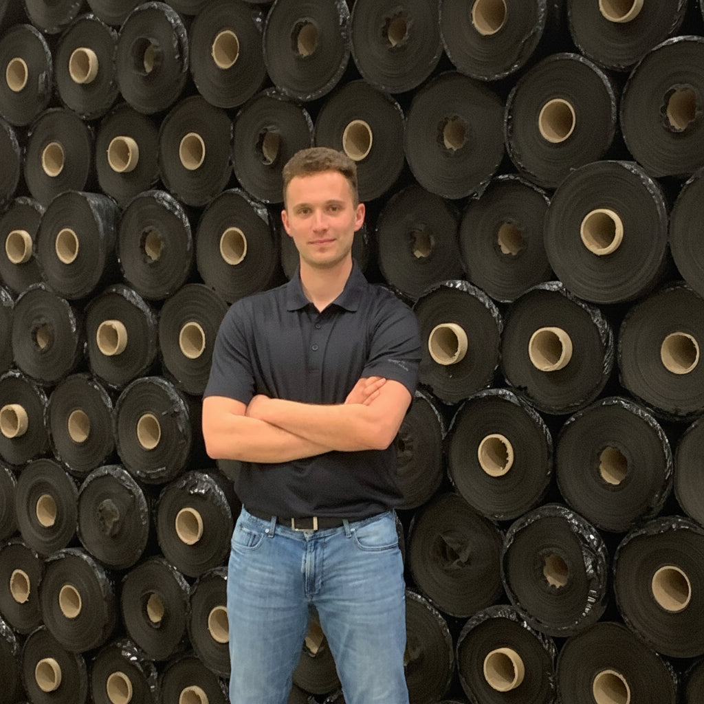 Matt, founder of RootPro, standing in front of geotextile fabric inventory in London Ontario